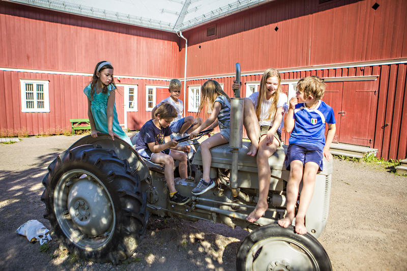 Mange barn sitter på traktoren Gråtass