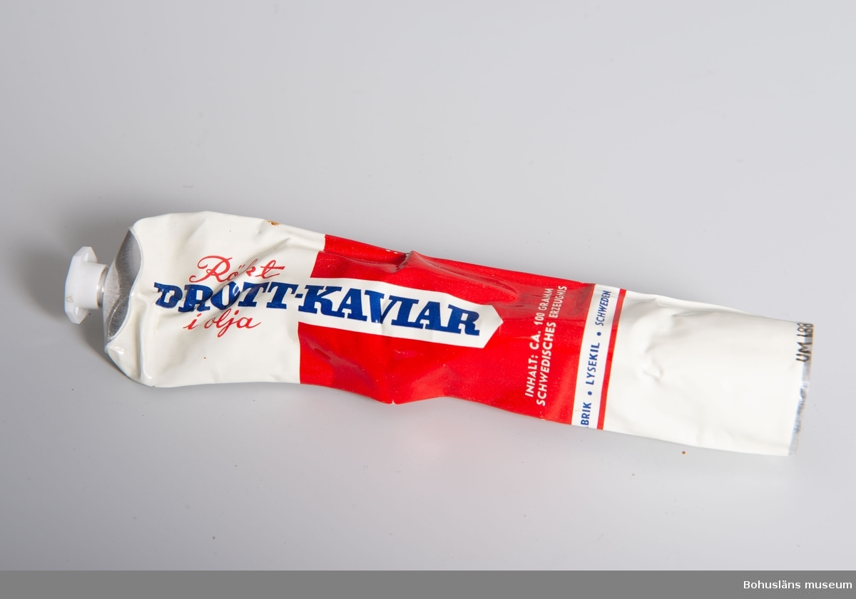 Tub för: "Rökt Drott-Kaviar i olja". Blå, röd och vit tub med
text på svenska, tyska. Från A.B. Öhnbergs Konservfabrik, Lysekil.