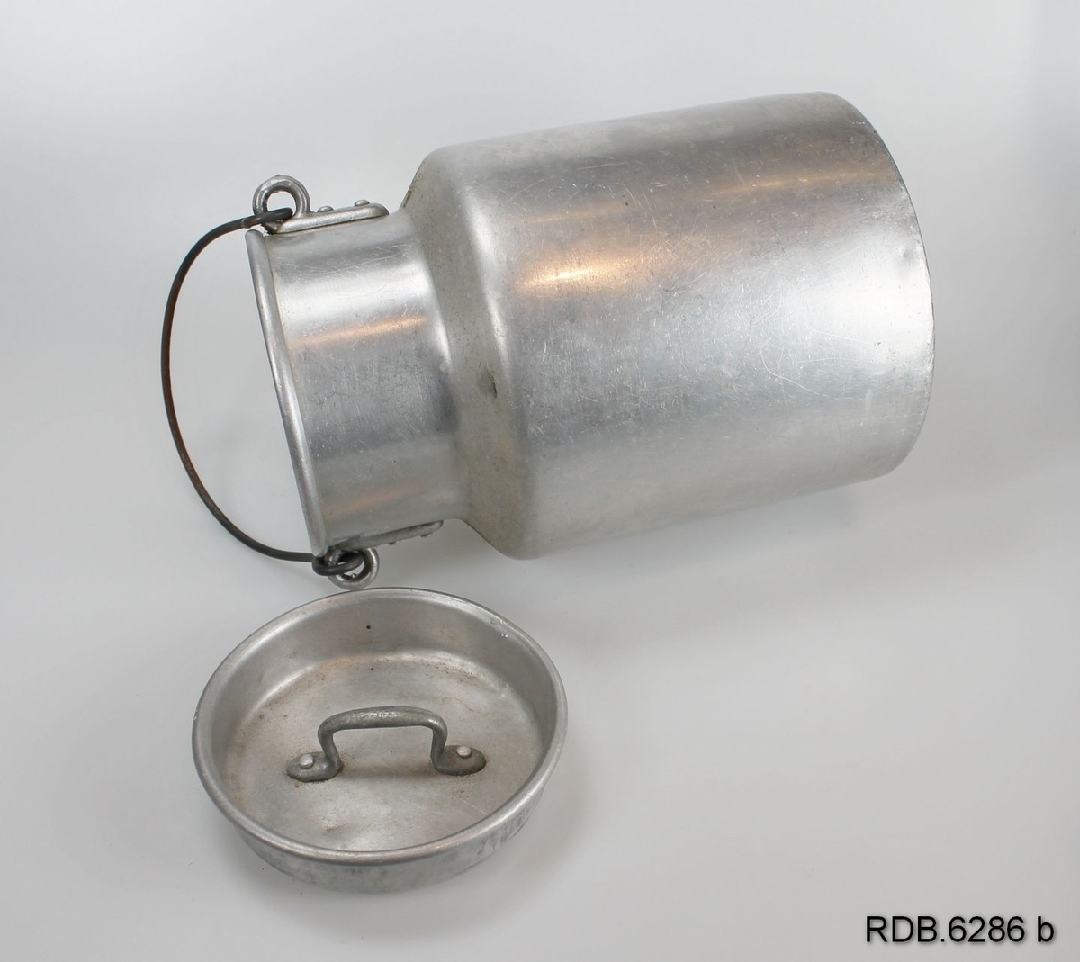 Sølvfarget 2-liters aluminiumsspann med hals, hengslet hank og løst lokk med håndtak.