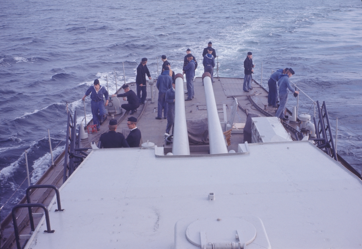 Bilden föreställer besättningsmedlemmar på jagaren Öland som står på akterskeppet och håller utkik på havet.