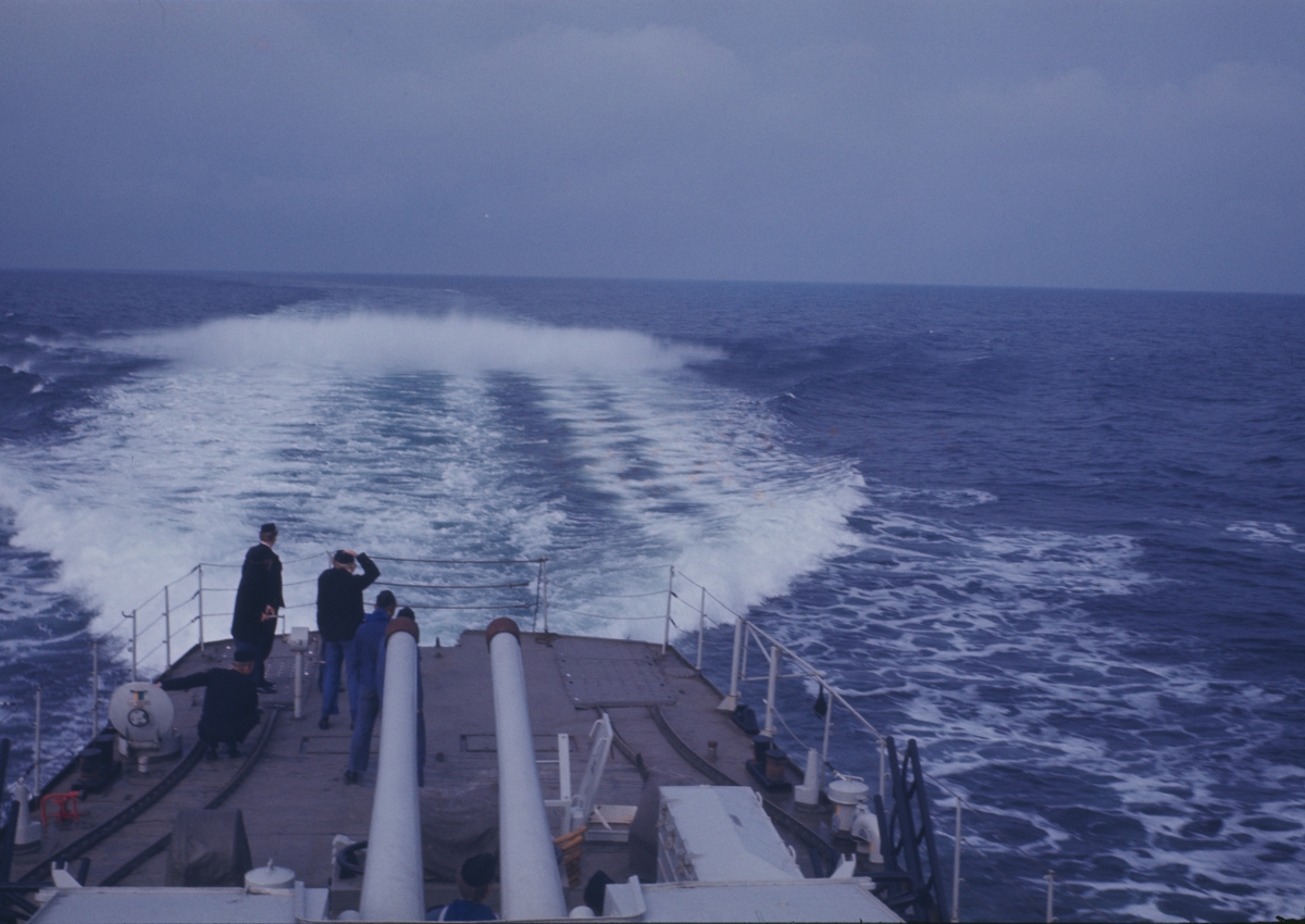 Bilden föreställer besättningsmedlemmar på akterskeppet av jagaren Öland som som iaktar en explosion bakom fartyget.