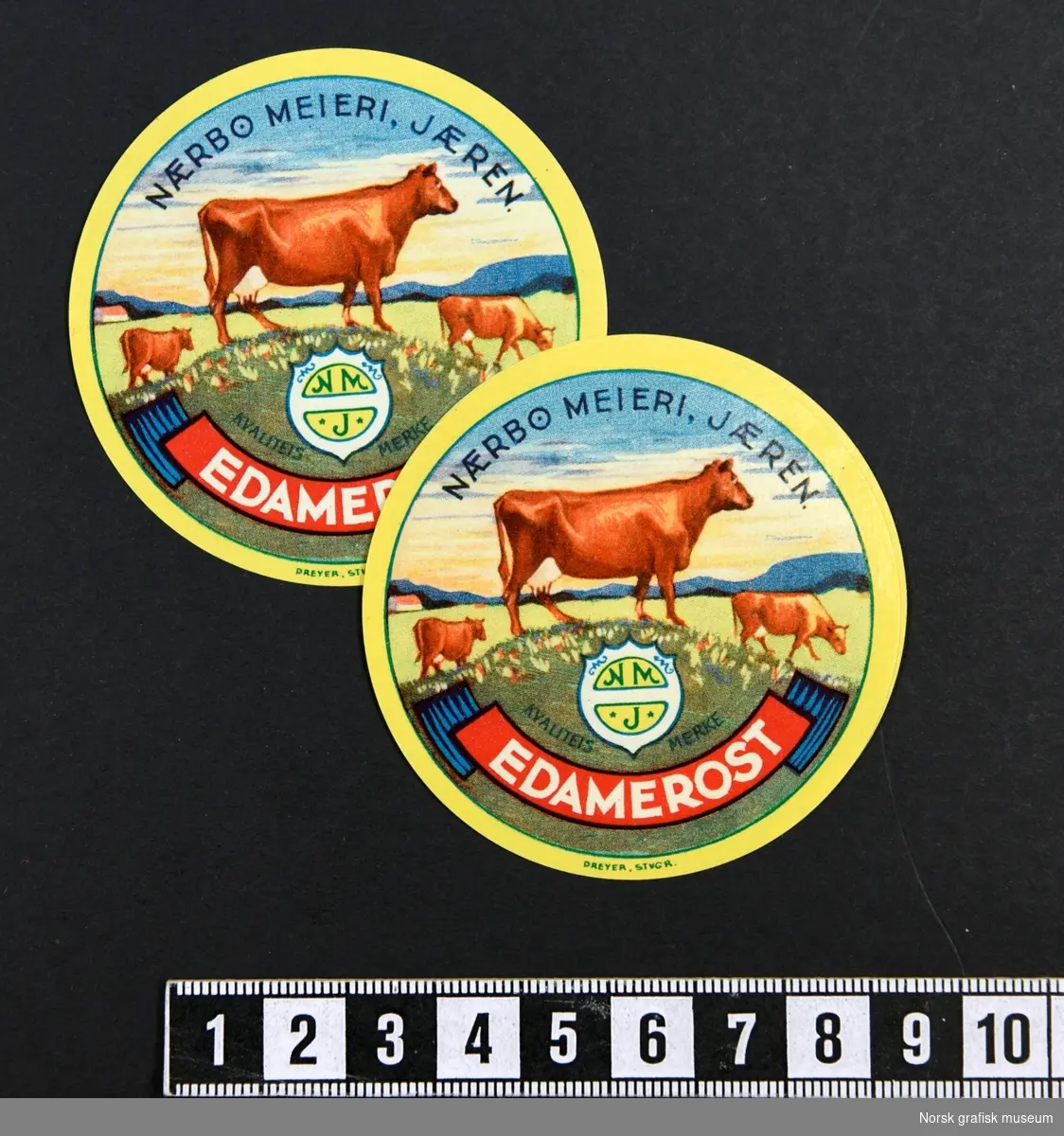 Runde etiketter med gul ramme rundt et motiv av kyr på en eng. 

"Edamerost"