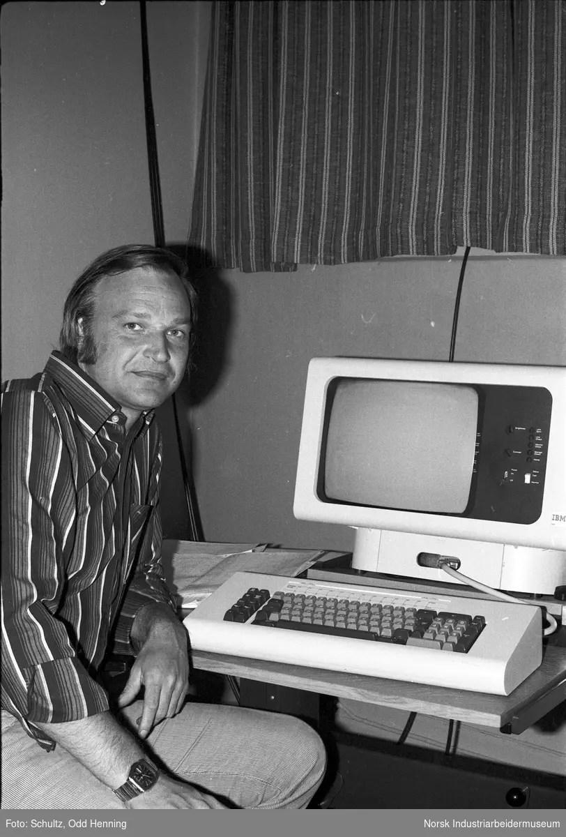 Portrett av mann som sitter ved en datamaskin.