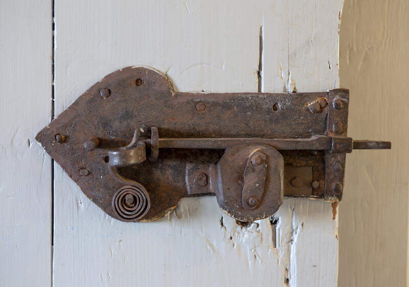 Et gammelt, rustent låseskilt med pil-/ hjertfasong og intakt nøkkel.