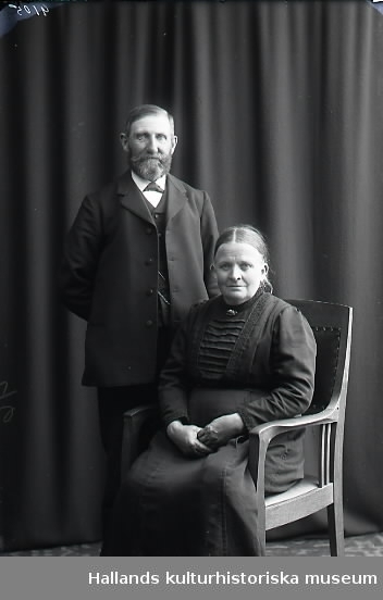 Ateljébild, parporträtt av man och kvinna i halvfigur där kvinnan sitter i en karmstol. Beställare: Karl Larsson.
(Se även bild nr GB2_5776)