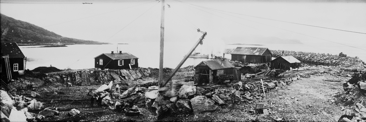 Område med steinbrudd, naust, skinner som fører ut til havet. Fotografert 1925.