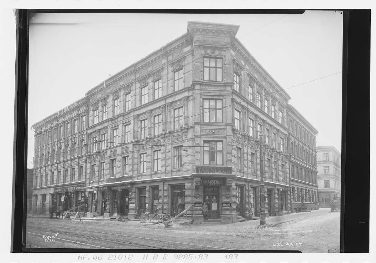 Bygård i Bogstadveien 25 med butikker i 1. etasje. Murmester Gundersen jobber på fasaden. Fotografert 1927.