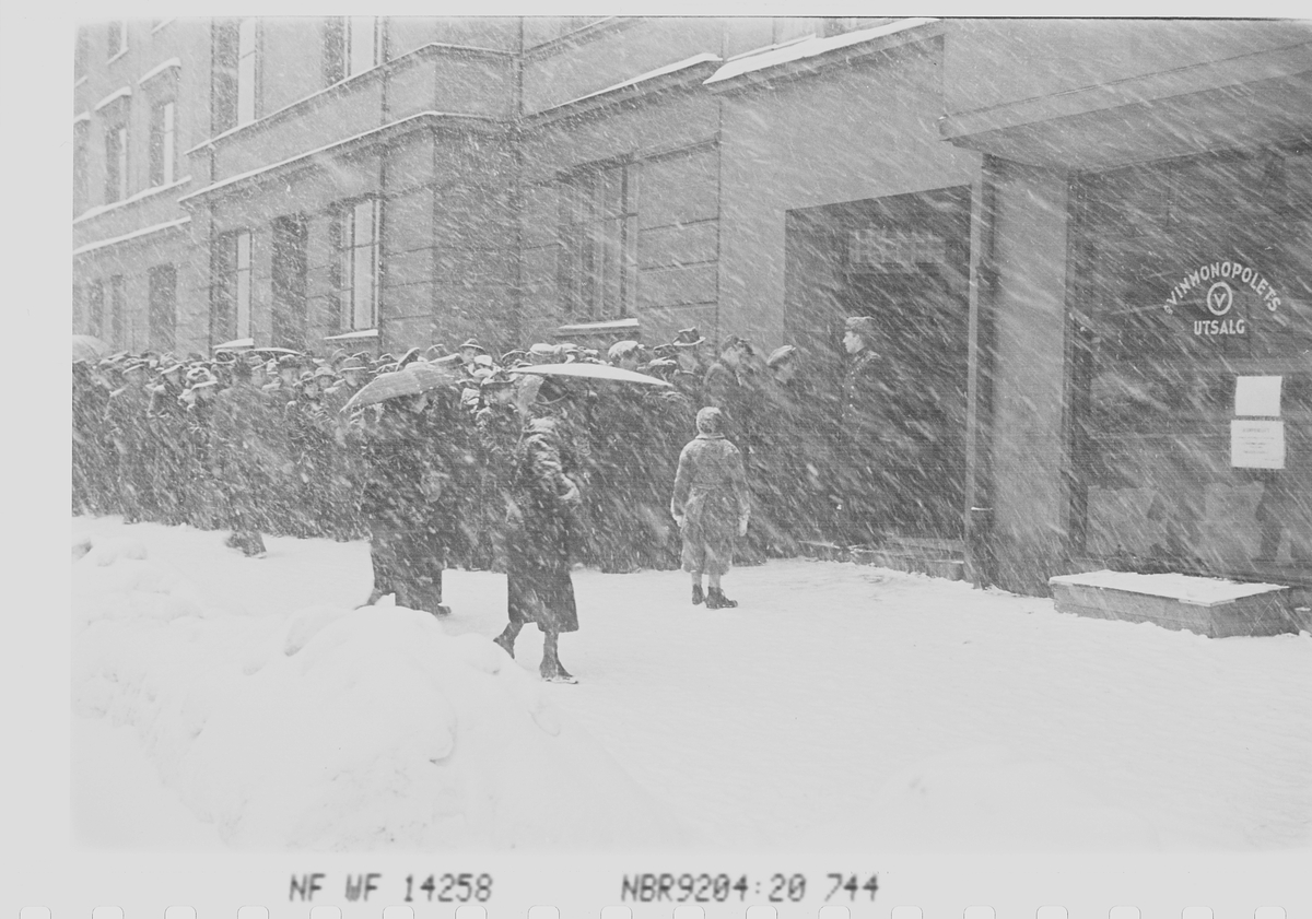 Kø foran vinmonopolets utsalg vinterstid ,Fredrik Stangs gate 41, Oslo.     1. mars i 1941.