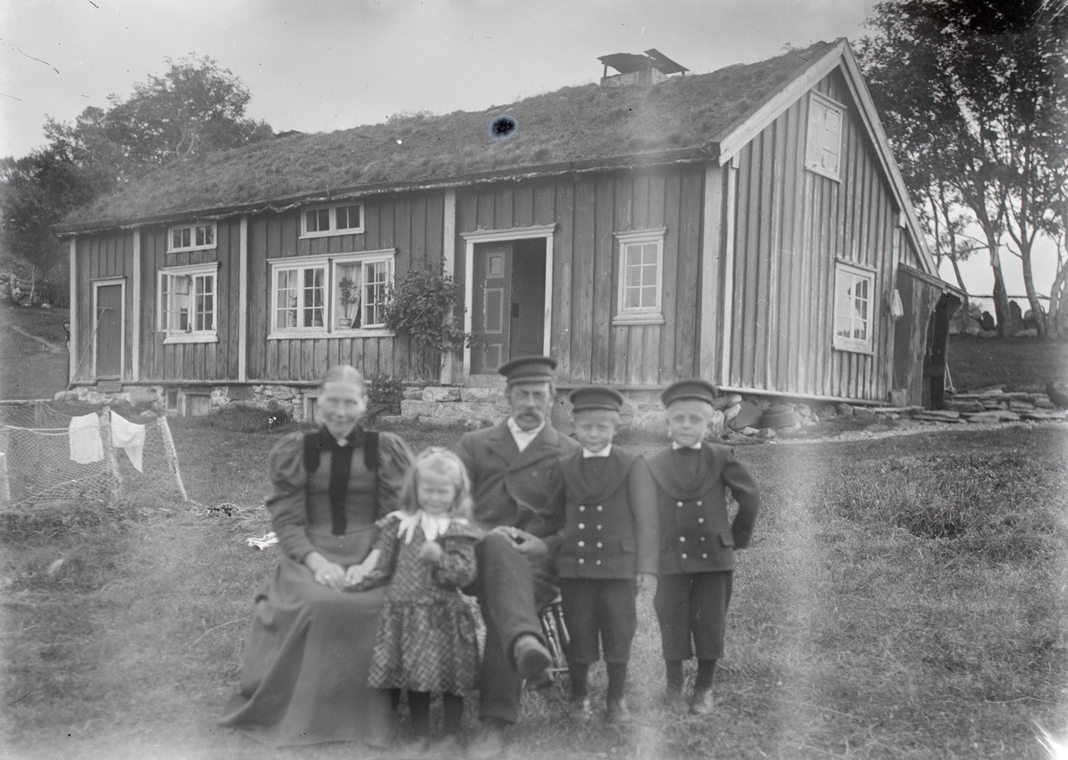 Gruppeportrett av en familie foran et hus.