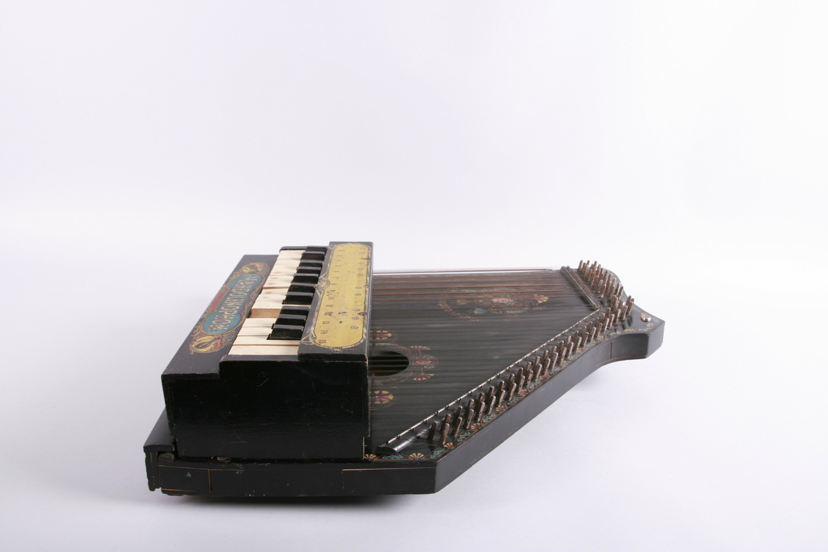 Citer med akkord- og melodistrenger. Avtagbar klaviatur som kan plasseres på melodistrengene.