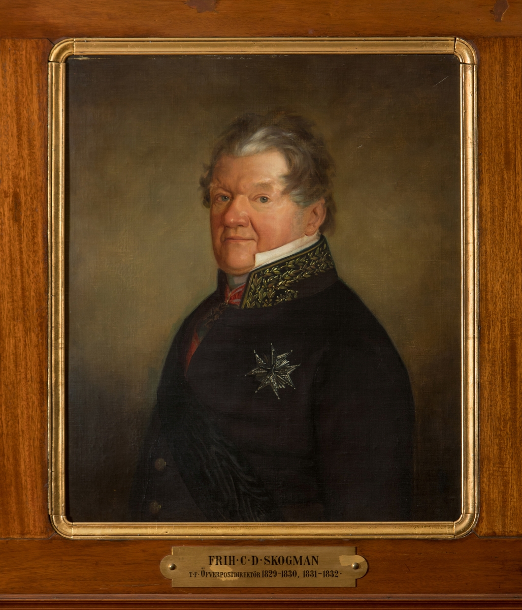 Porträtt i olja av friherre C.D. Skogman.

En mässingsskylt med text: "Frih C.D. Skogman, t.f. Öfverpostdirektör 1829-1830, 1831-1832". Duken är fäst på en plåt.