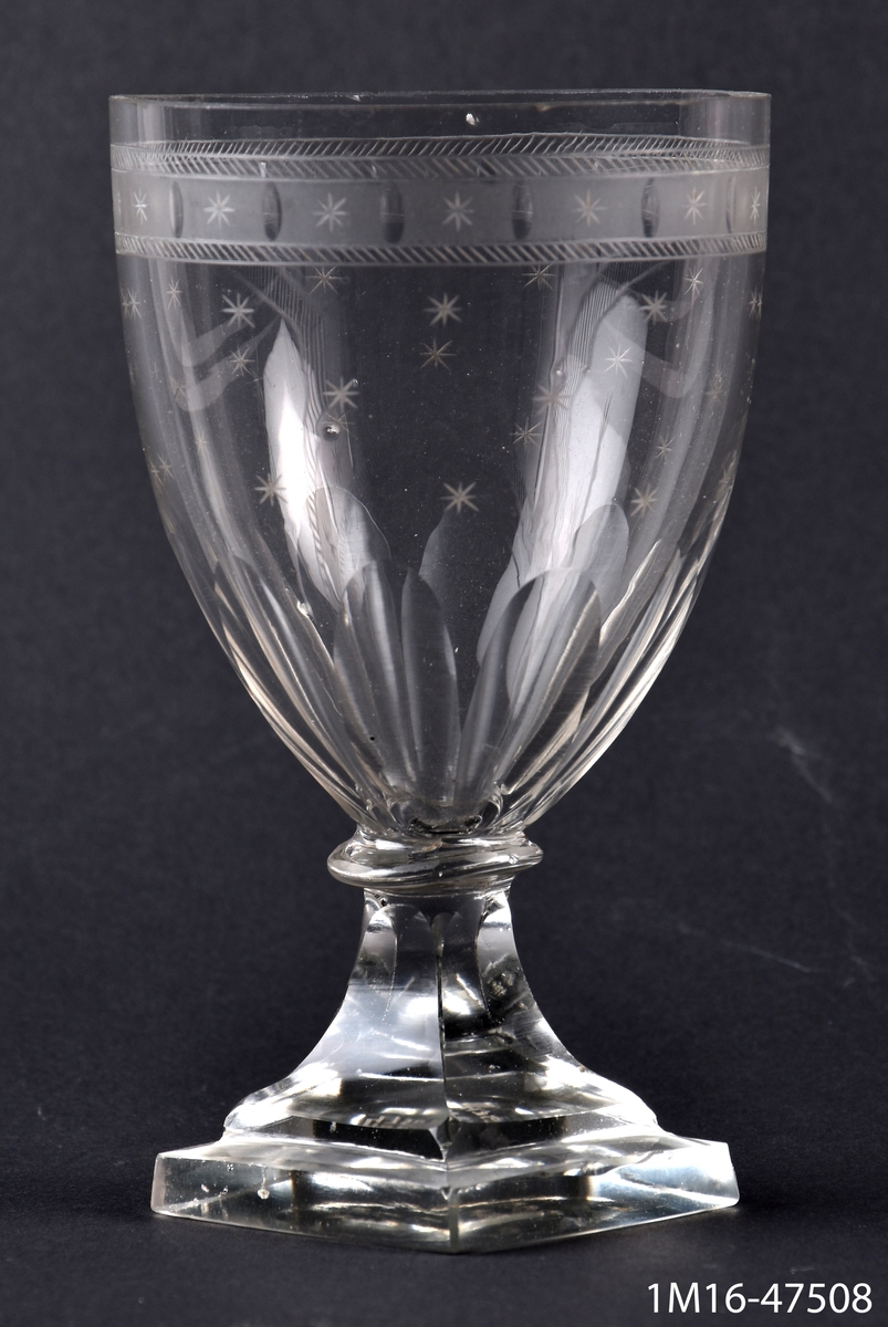 Ölglas, med fyrsidig fot, slipat och etsat, upptill en bård med stjärnor och små ovaler, längre ned stjärnor.
