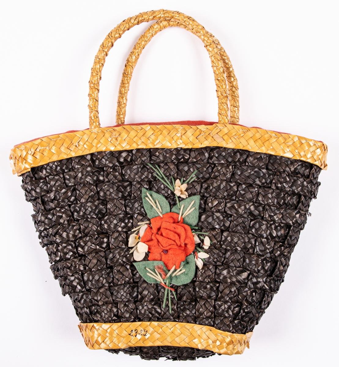 Handväska i form av en flätad korg, rött tygfoder, påsydda blommor av ylle.