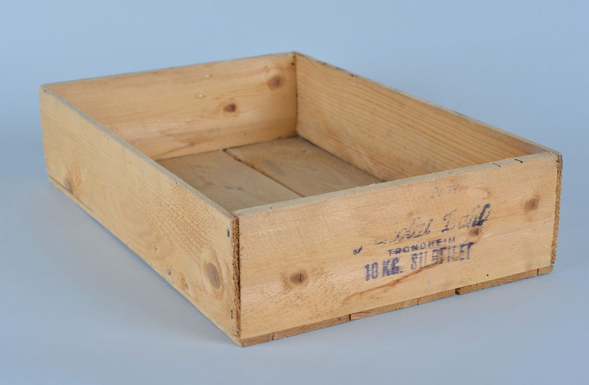 Rektangulær trekasse for oppbevaring og transport av sildfileter. 
Kassen har påtrykt logo for Nekolay Dahl på forsiden. 
Er spikret sammen med sidebord og tre bord i bunn.