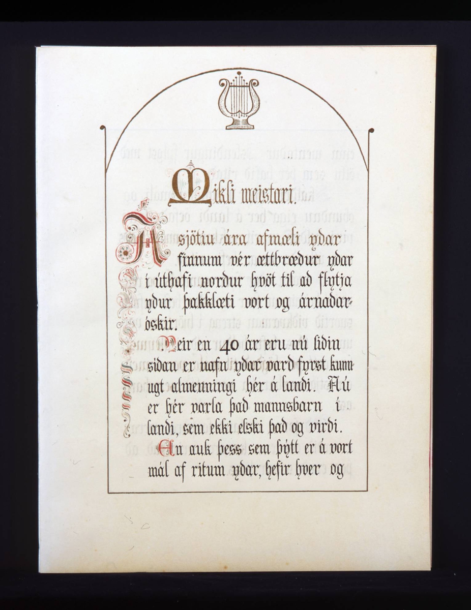 Adresse med mappe i mørkebrunt skinn med gullskrift på forsiden. Løse doble blad med mange hilsener i gullrammer. Adressen er skrevet med gotiske bokstaver i svart, rødt og gull.