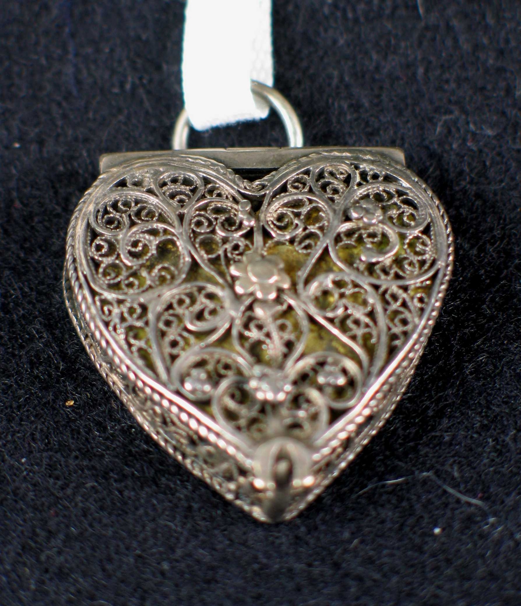 Sølvanheng i filigran formet som et hjerte. Forgylt plate som synes gjennom det gjennombrutte mønsteret.
