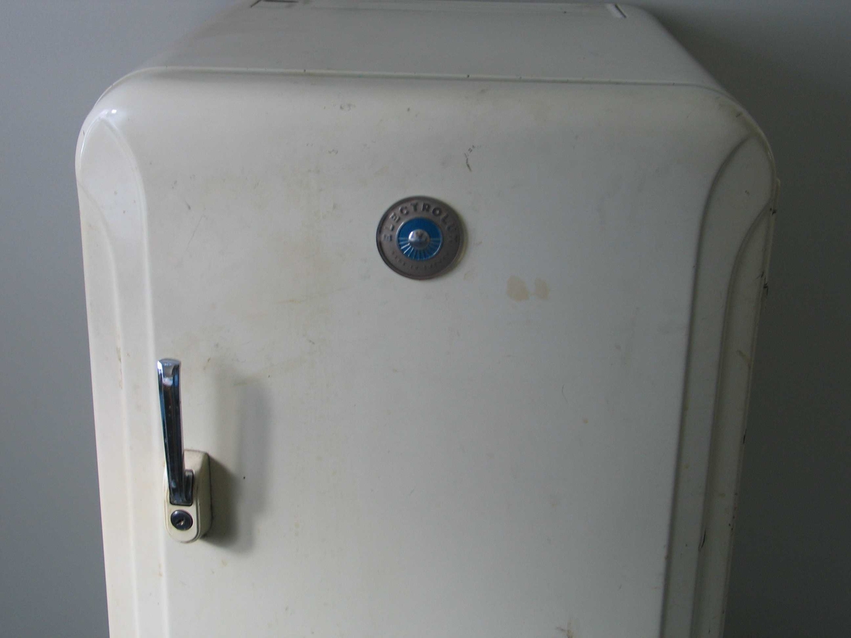 Hvitt kjøleskap med avrundede hjørner og metallhåndtak med lås.