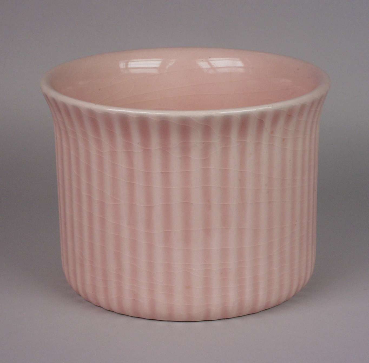Rosa glasert potteskjuler i keramikk med riflet mønster i godset.