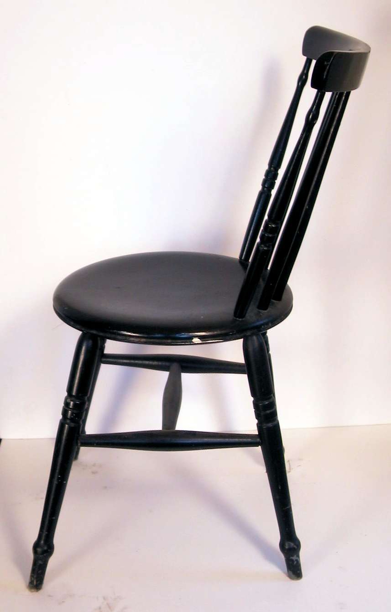 Sortmalt pinnestol med rundt sete og sprosser i ryggen 