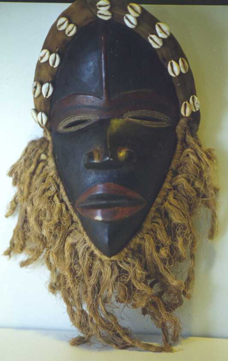 Maske, formet som et menneskeanskikt, m.lepper, nese, røde striper, skjegg, pannebånd m.skjell