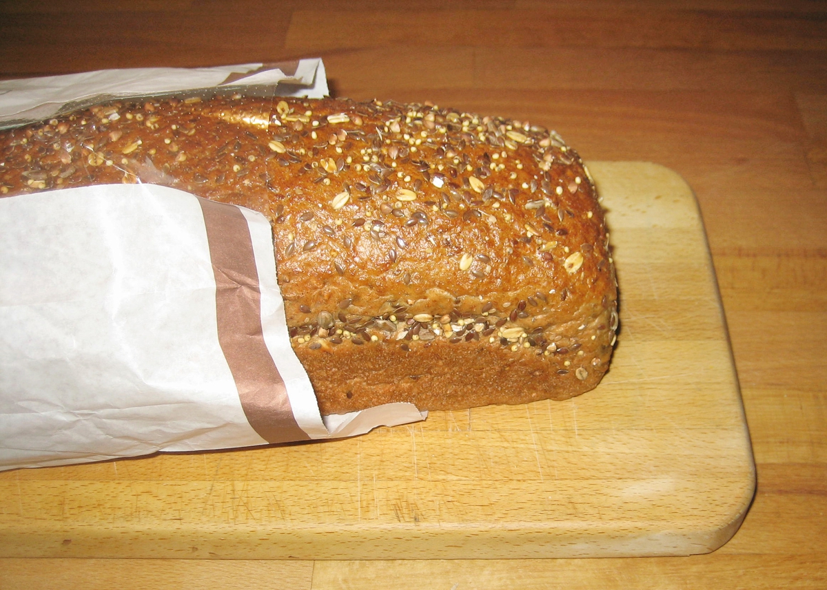 Forsiden: En tegning av en baker i bakerklær holder et nystekt varmt brød. Nøkkelhull ikon på forsiden.