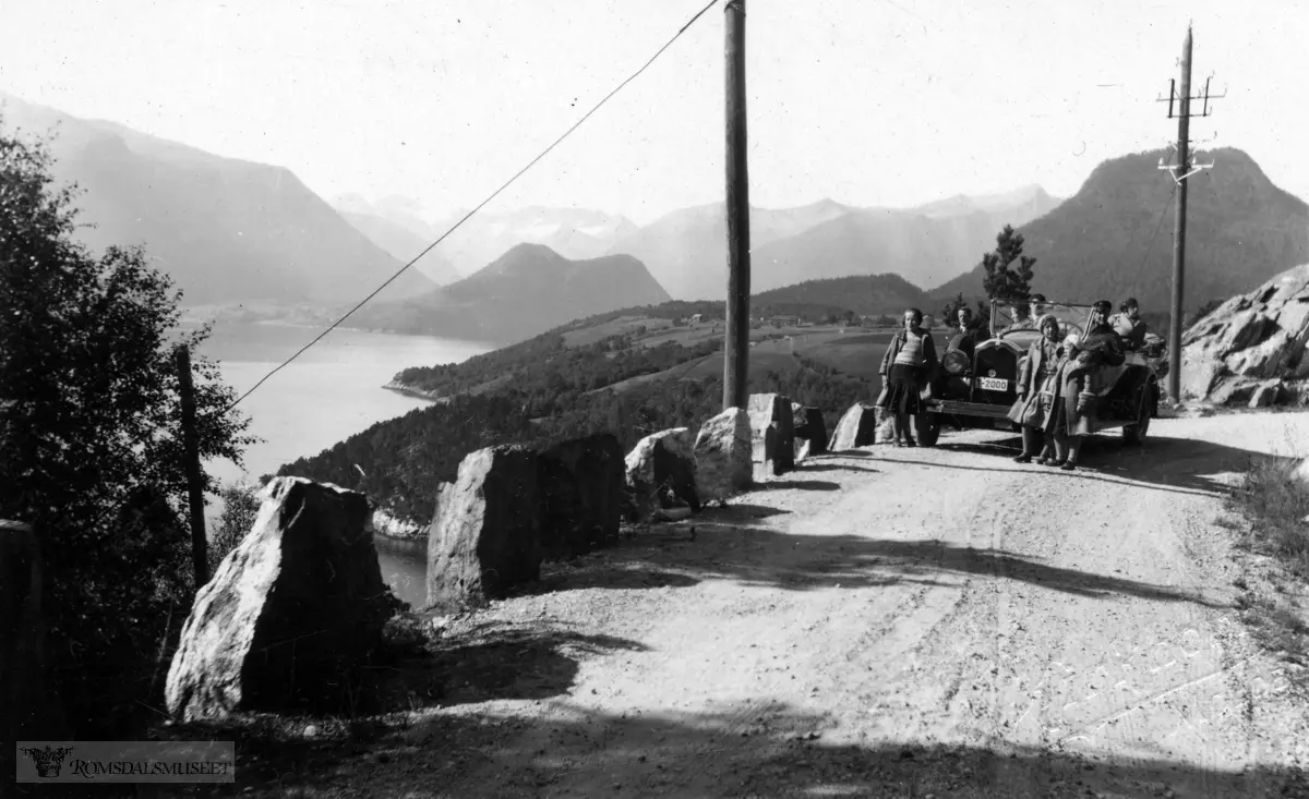 "På tur til Romsdalen sommeren 1933".1927 mod Buick personbil Drosje med reg nr T-2000 tilhørende Molde Auto..I bakgrunnen til høyre Torvikveten til venstre Hovdekollen.