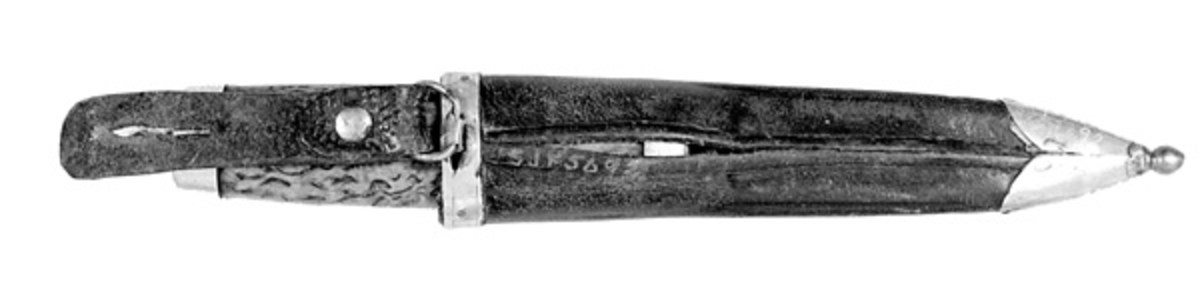 Kniv med slire, lagd og brukt av Johan Risberget (1862-1942) fra Våler i Solør. Kniven er 16,9 centimeter lang, målt fra bladspissen til og med knappen i den bakre enden av skaftet. Bladet er forholdsvis kort, cirka 5,8 centimeter. Bredden ved brystningen er snaut 2,0 centimeter. Her er tjukkelsen drøyt 4 millimeter. Bladet er kraftig nedslipt. Det har ingen smedstempel. Ei noe riflete overflate kan tyde på at stålet er fra ei fil. Skaftet er lagd av brunbeiset valbjørk. Valbjørka kommer fra Braskerud gård. Skaftet er rett, noe konvekst i lengderetningen og har et ovalt tverrsnitt. Begge ytterendene er forsterket med cirka 8,5 millimeter brede nysølvholker med glatte overflater (uten inngravert dekor). Tangen - jernteinen i forlengelsen av bladet - er tappet gjennom den sentrale delen av skaftet. I den bakre enden er enden av tangen omsluttet av en dreid knapp. 

Slira er 15,0 centimeter lang. Den er sydd av mørkebrunt lær. I den nedre enden er det påsatt en doppsko av nysølv med kuleformet endeledd. Kula har ei gultone som kan minne om messing. Rundt sliremunningen er det påklinket en 7,4 millimeter bred holk, også den av nysølv. Læret på forsida av slira ser ut til å ha hatt et påstemplet mønster, muligens akantusranker. Sømmen på baksida av slira er delvis oppsprukket. På baksida av munningsholken er det montert ei ståltrådhempe. I den er det festet en cirka 7,5 centimeter lang lærstropp med ei vertikal spalte som kunne kneppes på en knapp knivbrukeren hadde i bukselinninga.