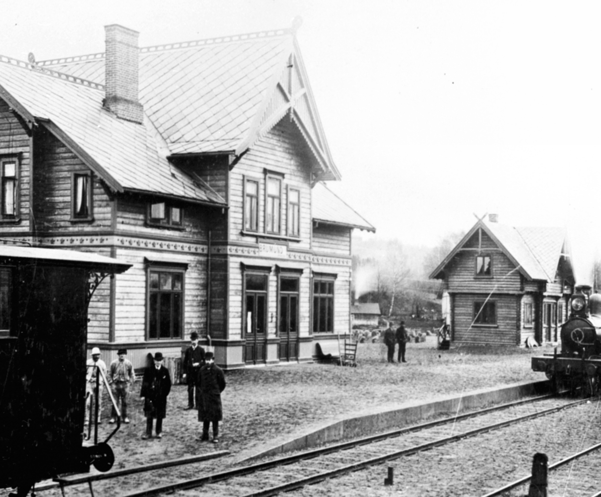 Eksteriør, Brumunddal jernbanestasjon, godshus, 7 menn på perrongen, merk navnet er Brumund.
