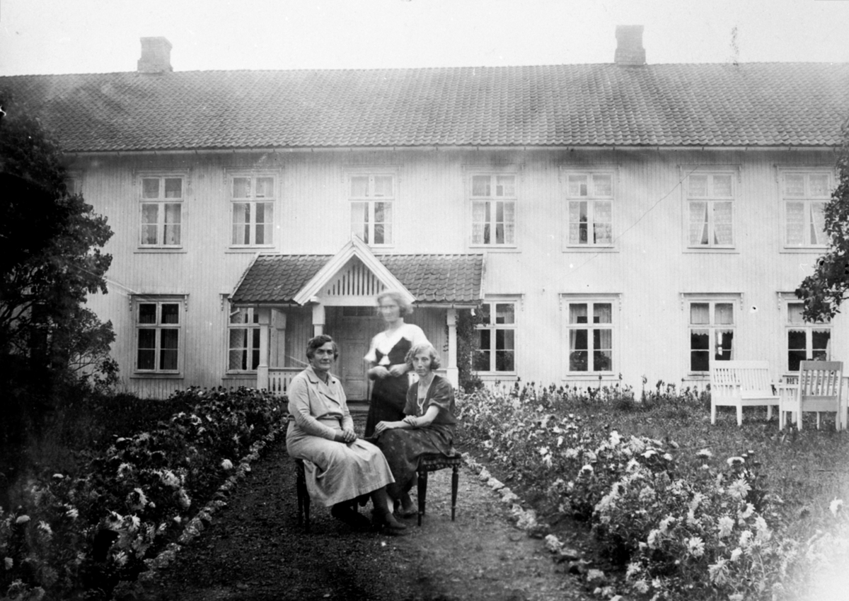 Eksteriør, hovedbygningen på Fossum, Nes, Hedmark. 3 damer ved blomster bed. Anna Storlien f.1875 med sine døtre Magdalena Sterud (1902-1994), Asbjørg Haram f.1909.