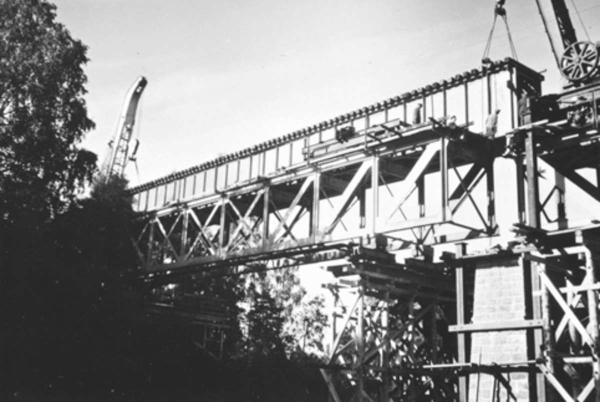 Bygging av jernbanebrua, Moelv. Nytt bruspenn heises på plass natten til 9. juli 1956.