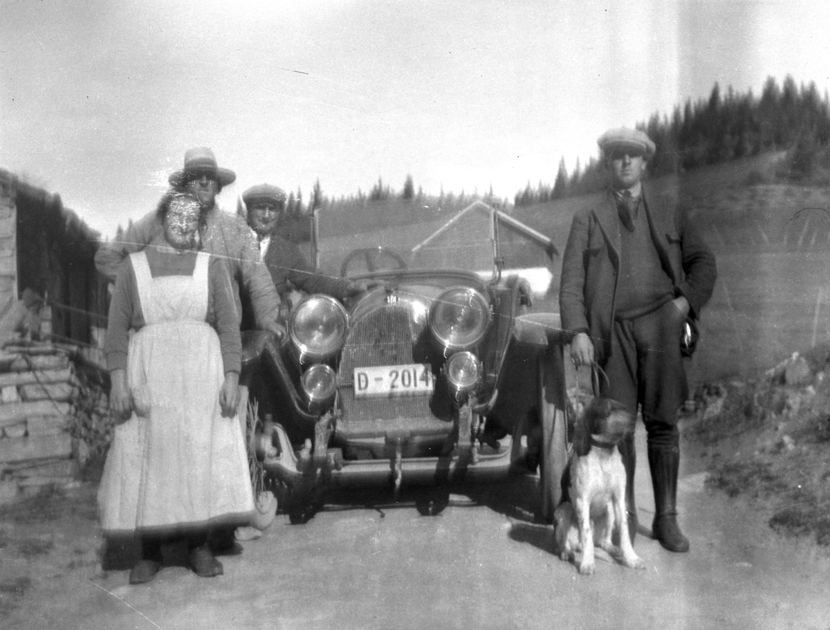 Ukjente personer  ved  personbil med  registrerings nummer D-2014. Bilen er en italienskprodusert S.P.A, og er registrert i ca 1924 på gårdbruker Olav Moslet i Ringsaker.

Kilde: Bilboken for Norge 1925.