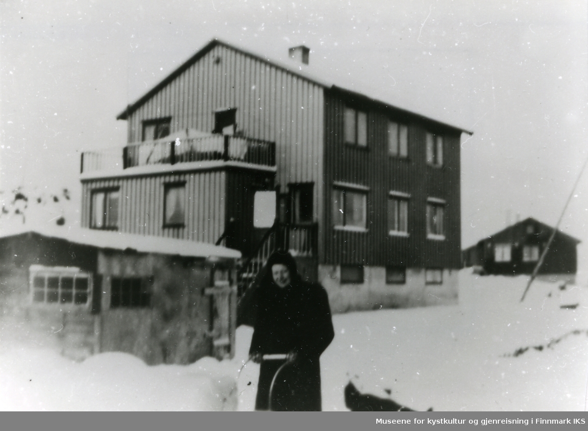 Kvinnen med barnevognen er ukjent.
Bygningen tilhørte Peter Rasmussen, og huset lengst borte tilhørte Hjørdis Leion.