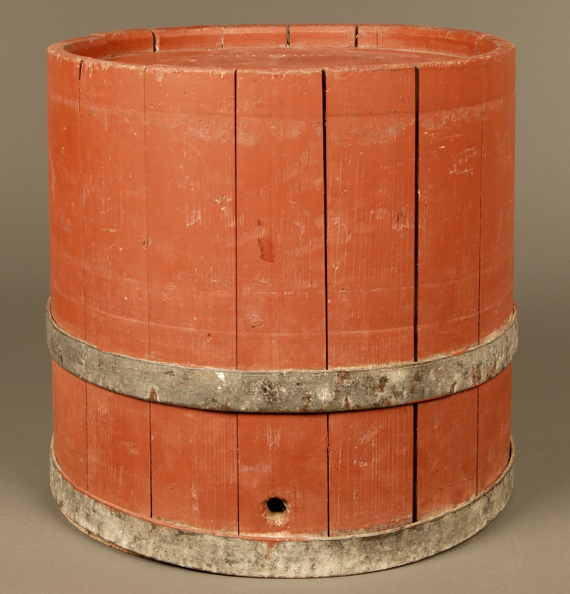 En rødmalt bøkret tretønne med to band av jern. Et hull på cirka 8cm i diameter på topplokket. Påskriften O.O.Klæt.
