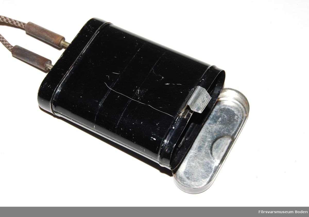Otoskop med batteribox, men övriga tillbehör saknas. Används för öronundersökningar. Utbytbara munstycken med bajonettfattning. Vridbar försättslins vid okularet samt munstycke för luftslang. Handtaget har en strömbrytare för belysningen. Batteriboxen är avsedd för 4,5 V ficklamsbatteri.Tillverkat i Tyskland och märkt 1934, vilket eventuellt kan vara tillverkningsår. Också märkt D.R.M.G., vilket är en form av mönsterskydd och står för Deutsches Reichsgebrauchsmuster. Förkortningen användes på tyska produkter t.o.m. 1952.