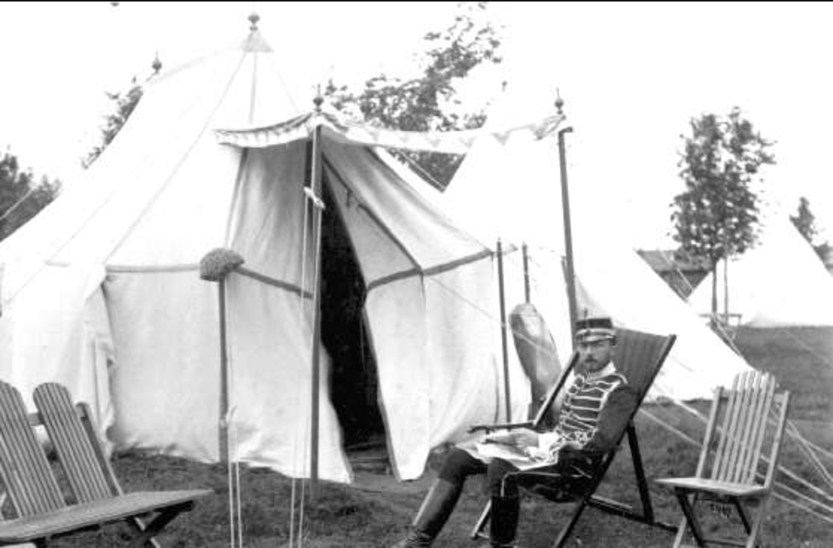 Prins Eugen framför sitt tält på Sanna Hed. OBS, mankskyddet ("padden") på tork på vänstra stolpen. OBS, bild och kartong hör sannolikt inte ihop. Franske fotografen J.David fotograferade troligen ej på Sannahed.