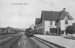 Moss stasjon med stasjonsbygningen og damplokomotiv med tog