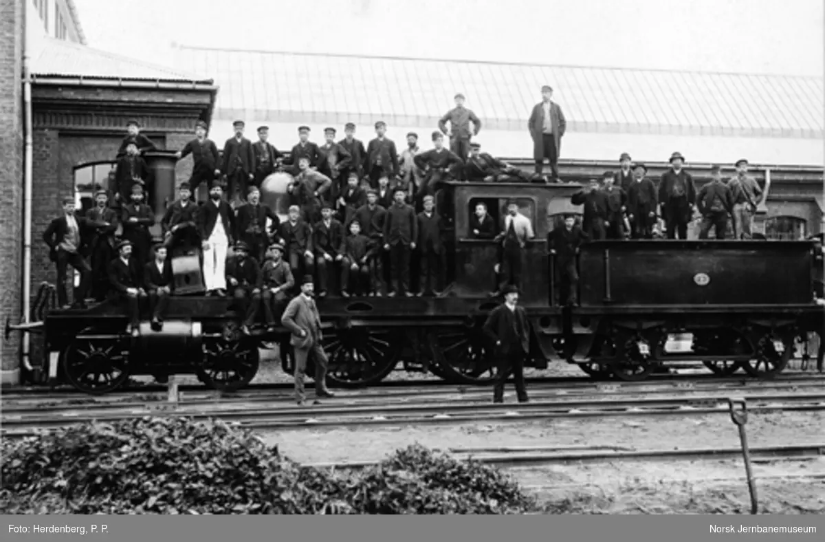 Gruppebilde av jernbaneansatte på damplokomotiv nr. 73
