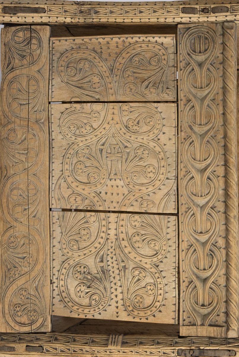 Fire søyler med skåret dyrehode-ornamentikk, sammenføyet med tverrbord og fyllinger. Bunn er åpen foruten to tverrstaver. Hele utsiden er rikt dekorert med utskåret dyr og ranker.