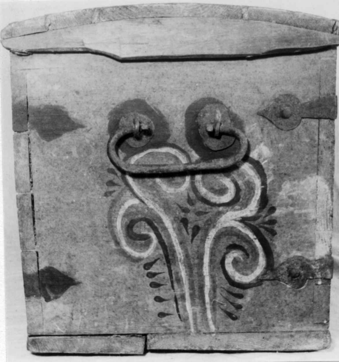 Kiste med svakt buet lokk. Malt dekor på alle sider og jernbeslag.