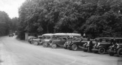 Utenbys besøk 1933. Biler parkert i veikanten utenfor hovedi