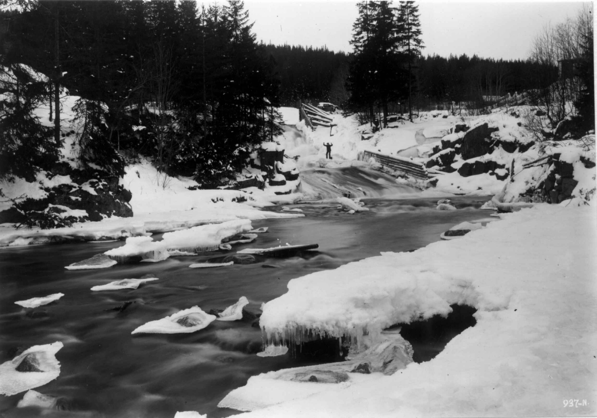 Oslo, Hammeren, Maridalen 1909. Vinterbilde av elvestryk. Mann står ved bredden. Skog.
