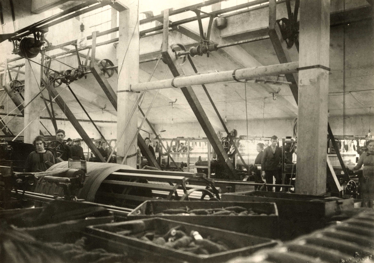 Fabrikkhall med maskiner og arbeidere.