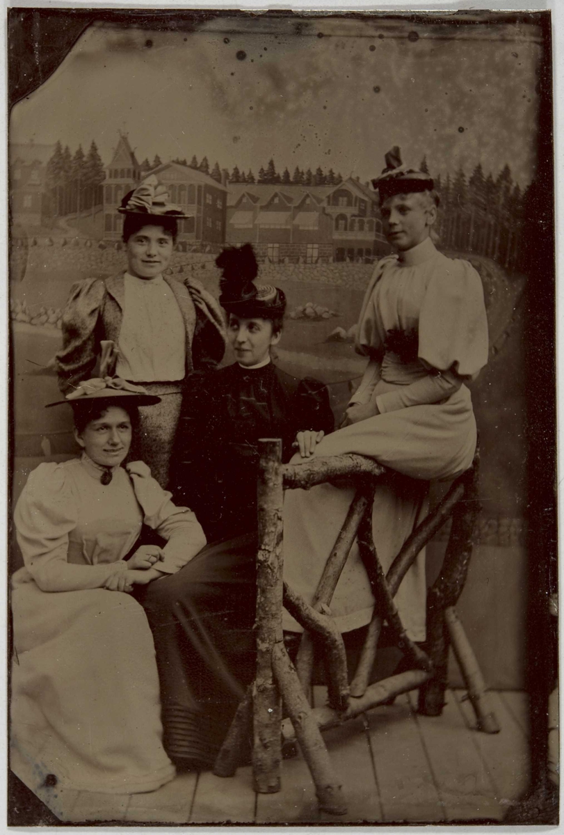 Portrett av fire kvinner, ukjente. De poserer i helfigur, sittende og stående, i atelier med malt bakteppe (motiv?) og rekvisitter. Fra familiealbum som har tilhørt Magda Thaulow. 