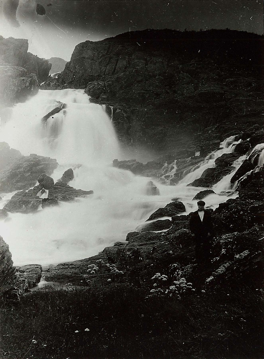 Adamsfjordfossen, Lebesby med mann i samisk drakt stående t.h. Del av ...