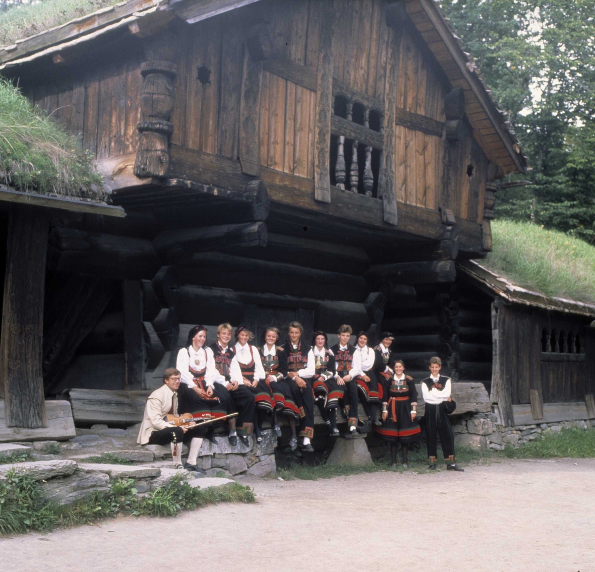 Norsk Folkemuseums dansegruppe foran Oseloftet, bygning nummer 003 i Setesdalstunet på Norsk Folkemuseum.