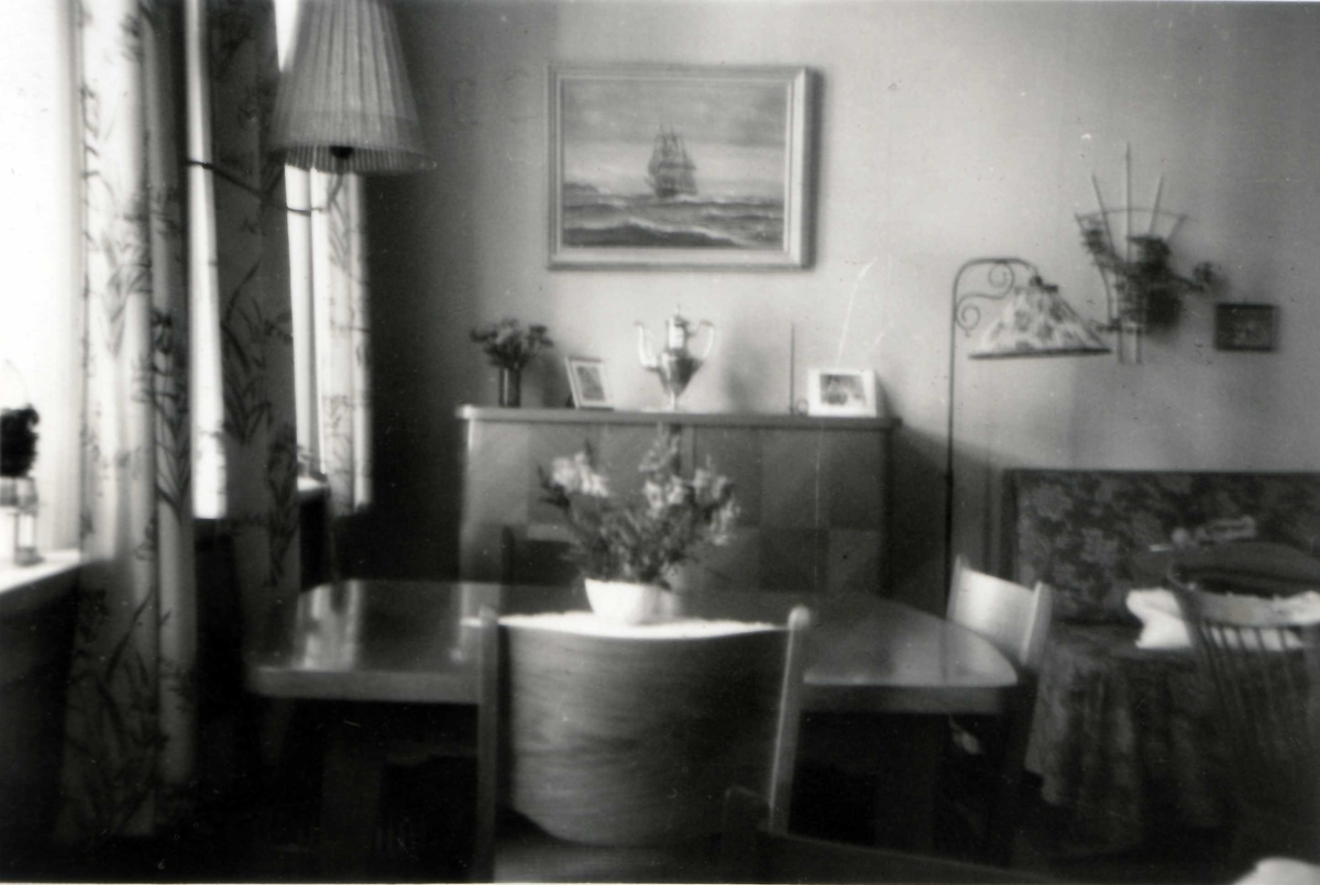 Stueinteriør med spisestuemøblementi, salongbord, divan, lampe, gardiner. Fra leilighet (ett rom og kjøkken) i Markveien 38, Oslo, ca. 1955