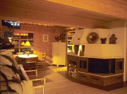 Peis  sentralt i rommet, spiseplass og hjørneskap, i hus i N