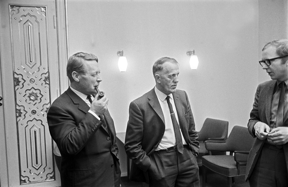 Serie. Finansdebatten i Stortinget. Ole Myrvoll med dokumenter og tre menn diskutere. Fotografert november 1970.
