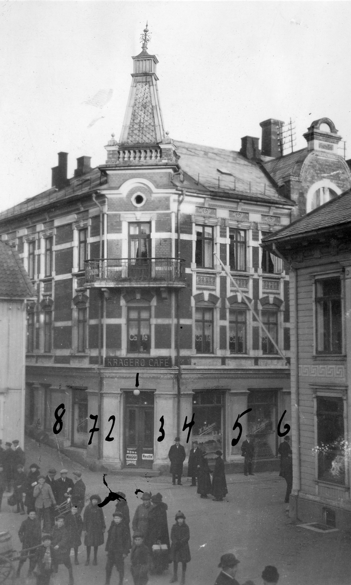 Butikk på torvet i Kragerø, 1932. Sifre er skrevet på fotografiet med blekk, ant. viser disse hvor Tiedemann skal sette opp skilt.