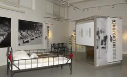 Utstillingsplakater med bilder fra Bastøy skolehjem. Sengene